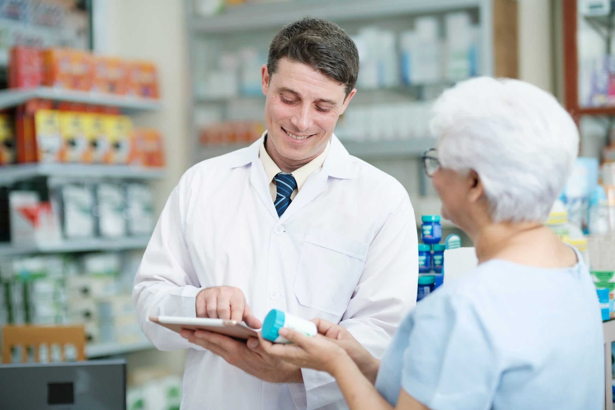 Profesional farmacéutico atendiendo a una persona en una farmacia